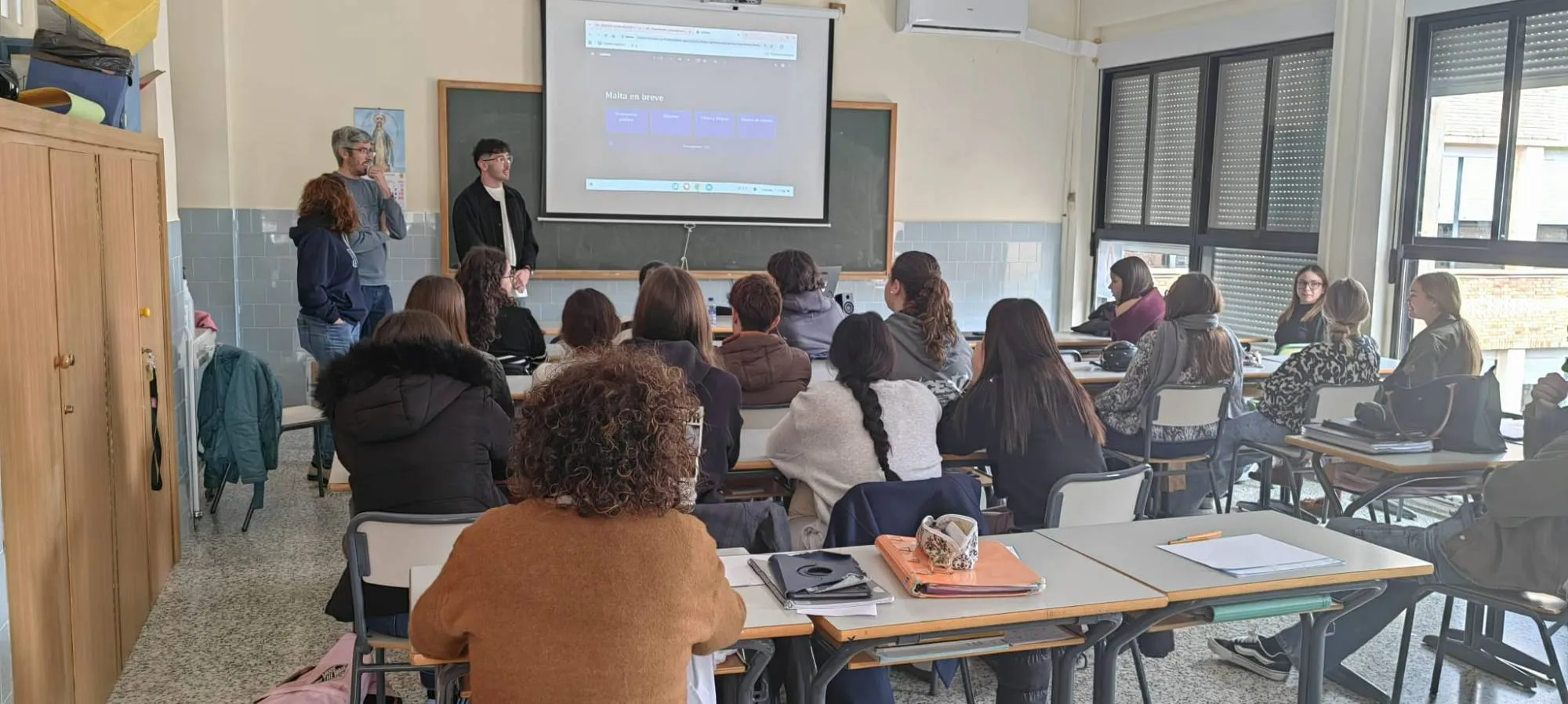 Students in a classroom watching a presentation about Malta
