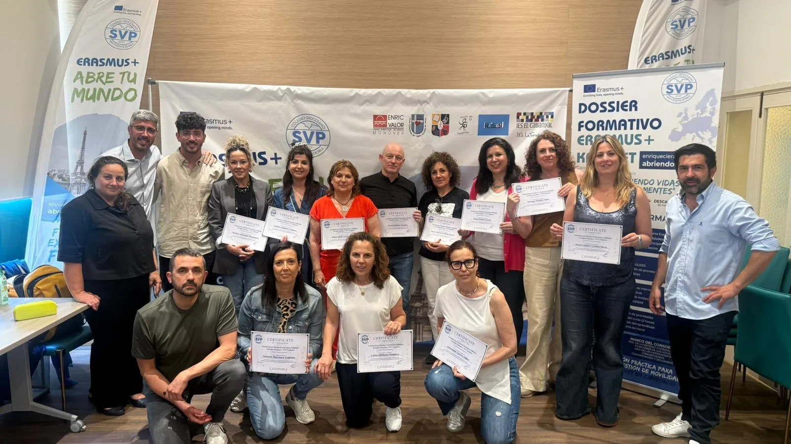 Group of teachers posing with their certificates in front of the consortium banners